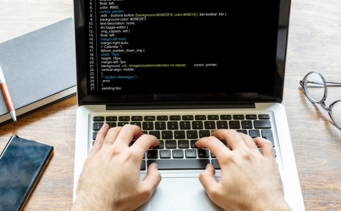 Man programming on a computer, office background
